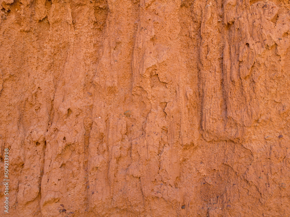 Texture of red clay. Natural natural patterns. Dry red background closeup.