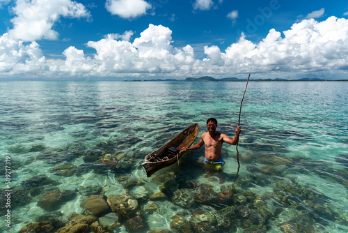 Bajau laut with his boat with clear coral reef in Semporna Sabah Borneo Malaysia