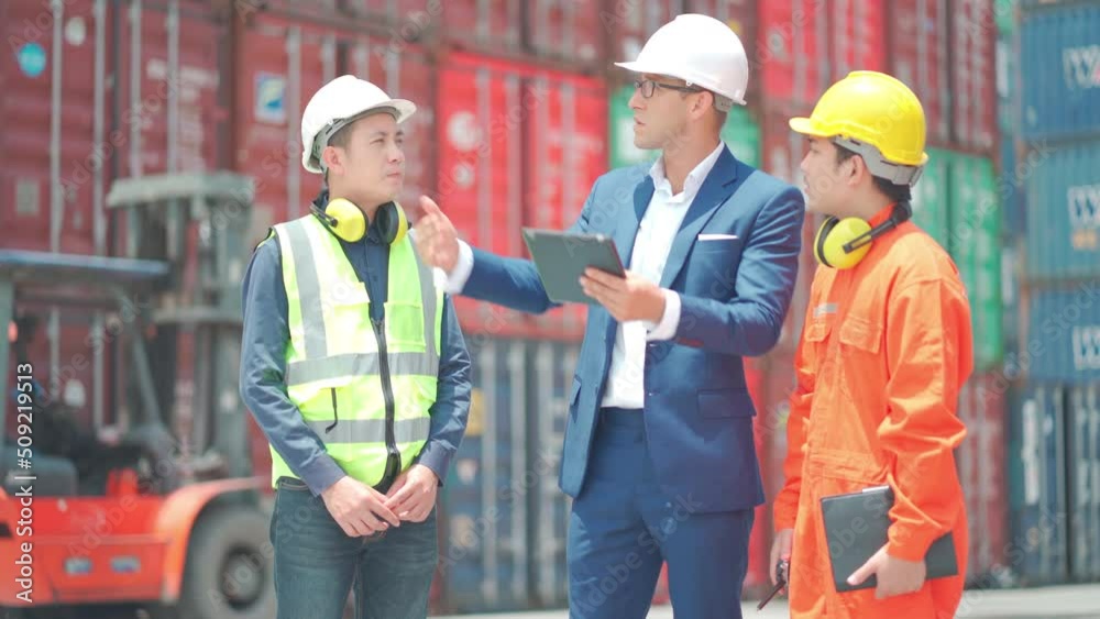 Wide shot group of cargo container workers with multiethnic including engineer or foreman and technician discuss together for project of import or export the transportation product in workplace. Wide shot group of cargo container workers with multiethnic including engineer or foreman and technician discuss together for project of import or export the transportation product in workplace.