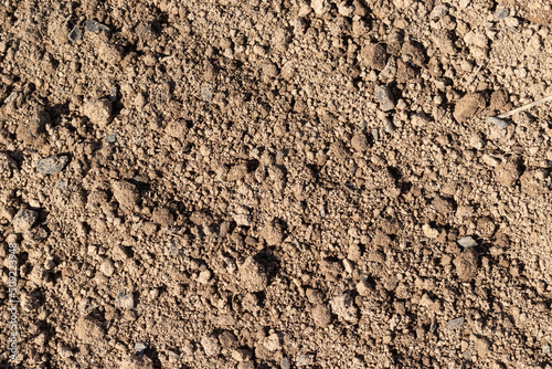 Empty plowed dry soil under sunlight closeup