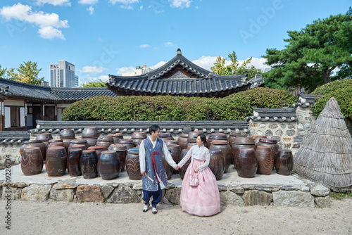 Fototapeta 한국의 전통 가옥의 장독대를 배경으로 손잡거나 인사를 하는 젊은 아시아 한국 남녀 모델