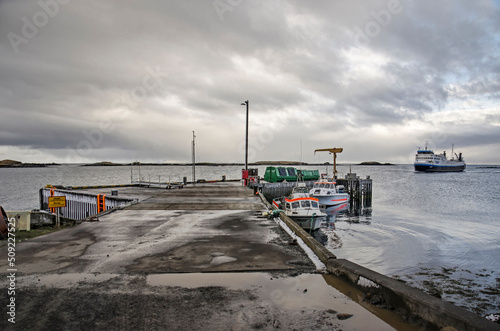 Flatey, Iceland, May 5, 2022: ferryboat Baldur approaches the island's harboron a cloudy day photo