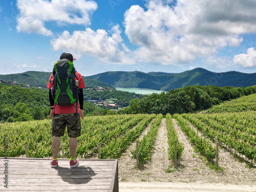 Man with backpack at vineyard and lake Abrau background in Abrau-Dyurso travel destination photo