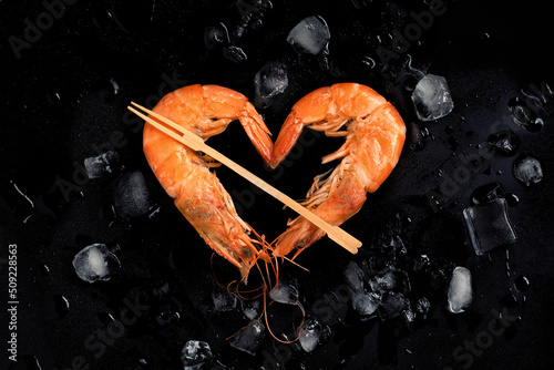 Cooked shrimps,prawns heart shape  on stone background with ice.Top view.Valentine's Day celebration.