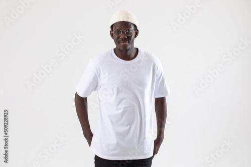 African american man in a white t-shirt stands on a white background.. Mock-up.