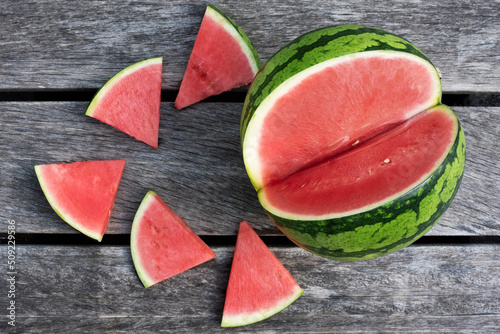 Seedles watermelon and slices on wooden background. photo