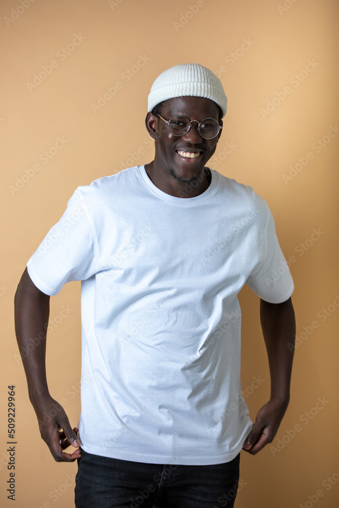 Attractive african american man in white t-shirt standing on orange background.