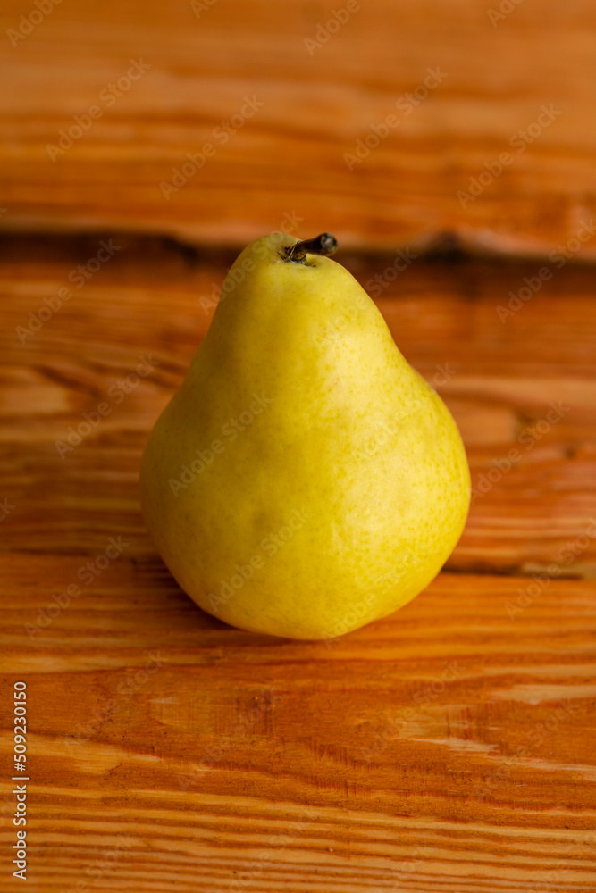 One ripe juicy pear on a wooden background close-up