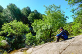 Man sitting on a large rock in the mountain hiking, Guadarrama Madrid.