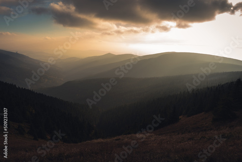 Landscape of warm light sun rays on sky through the clouds over the mountains in Czech republic, Jeseniky