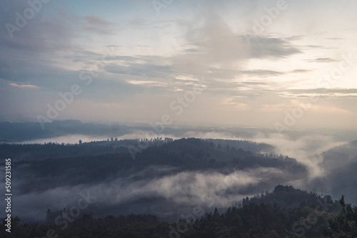 Foggy landscape. Misty foggy morning with sunrise in a valley of Bohemian Switzerland park. Landscape of Czech Republic, beautiful national park Bohemian Switzerland.