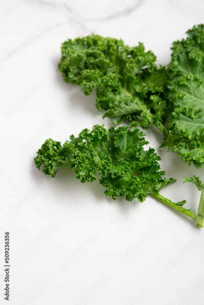 Green kale leaves on white surface food vegan Green kale leaves on white surface food vegan