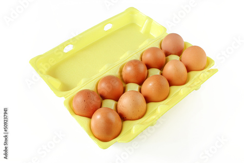Ten hen eggs in yellow styrofoam container isolated on white background photo
