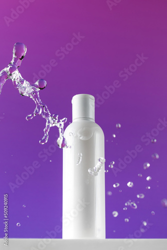 Bottle of mincellar water and splashes of natural cosmetic product for skincare photo