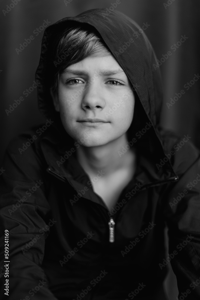 Black and white portrait of teenage boy on dark background. Low key close up shot of a young teen boy. Black and white photography. Selective focus Black and white portrait of teenage boy on dark background. Low key close up shot of a young teen boy. Black and white photography. Selective focus