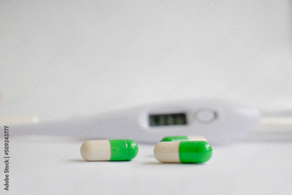 Thermometer, pills on a light background Thermometer, pills on a light background
