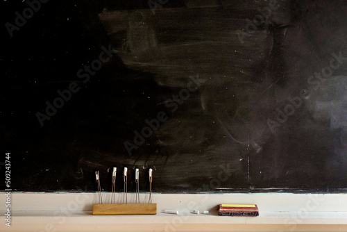 Blank blackboard with white chalk and eraser.