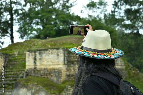 Mujer latina tomando un autorretraro en la Ruinas de Iximche en Guatemala. photo