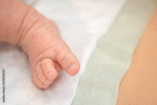 Little foot of a cute baby with selective focus. Adorable one month newborn girl 