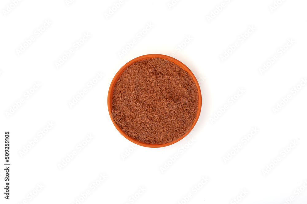 Bird cherry flour in clay plate on white background, top view. Shredded berry Bird cherry use in baking and healthy smoothie Bird cherry flour in clay plate on white background, top view. Shredded berry Bird cherry use in baking and healthy smoothie