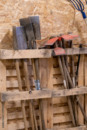 Spades and hoes, garden tools stored in a wooden shed