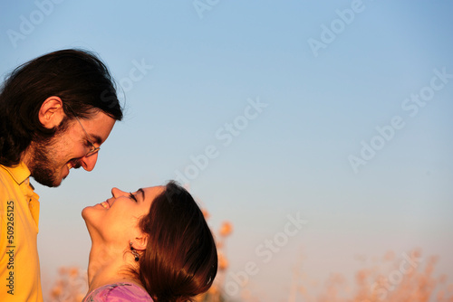 Sweet couple about to kiss on light blue gray sky background