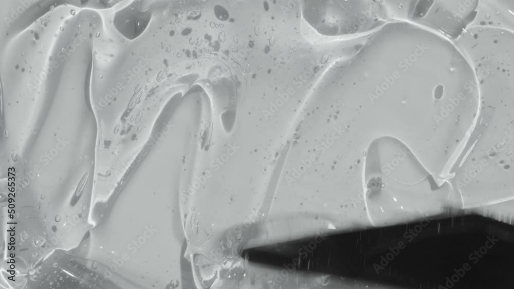 Serum gel with peptides texture spreading with spatula footage. Liquid cosmetic skincare toner beauty product with ceramide and collagen. Hyaluronic acid cleanser abstract background video 4k