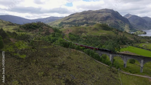 Steam Train on Glenfinnan Viaduct with Loch Shiel in the Background in the Scottish Highlands, UK photo