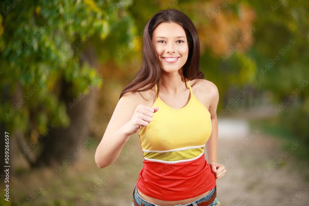 Happy slim woman wearing sportswear jogging in the city at sunrise. Workout exercise in the morning. Healthy and active lifestyle concept. Happy slim woman wearing sportswear jogging in the city at sunrise. Workout exercise in the morning. Healthy and active lifestyle concept.