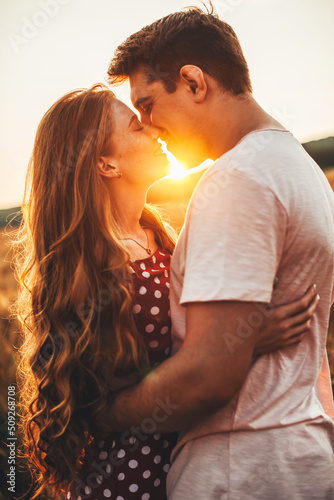 Quadro su tela Portrait of beautiful young couple in love, kissing outdoor