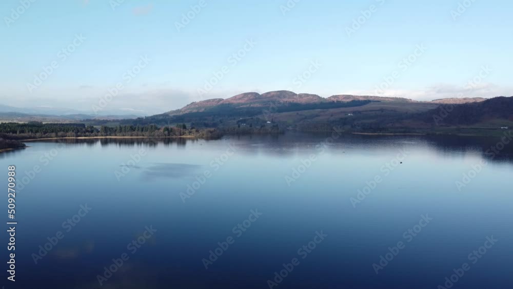 Lake with Ben Lomond mountain in background, Scotland. Aerial backward ascending