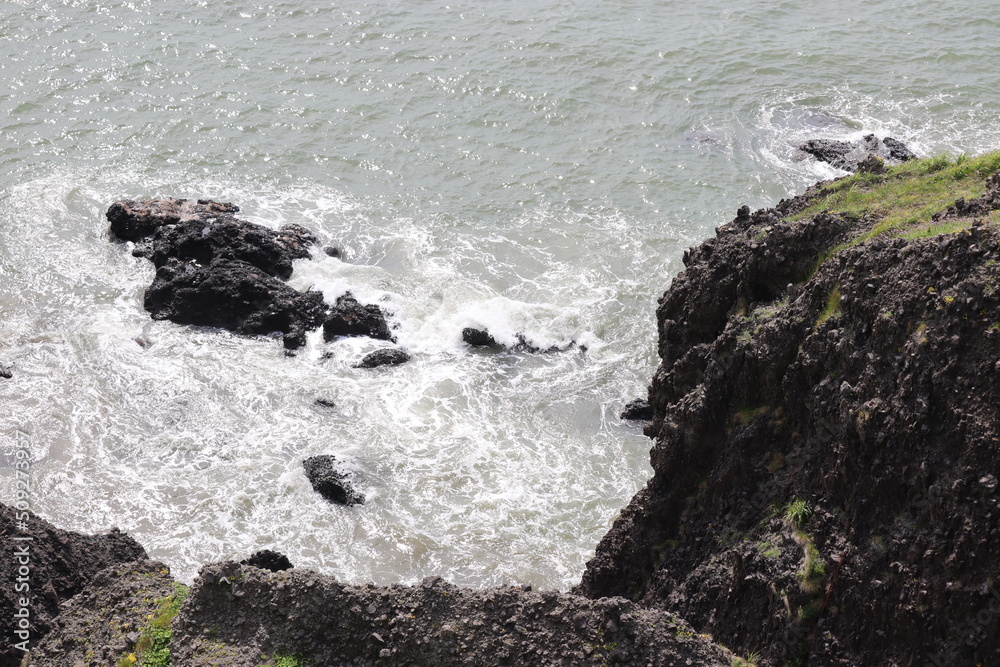 Fototapeta premium Rocky shore murky due to rough waves