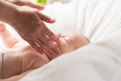 眠る赤ちゃんとお母さんの手