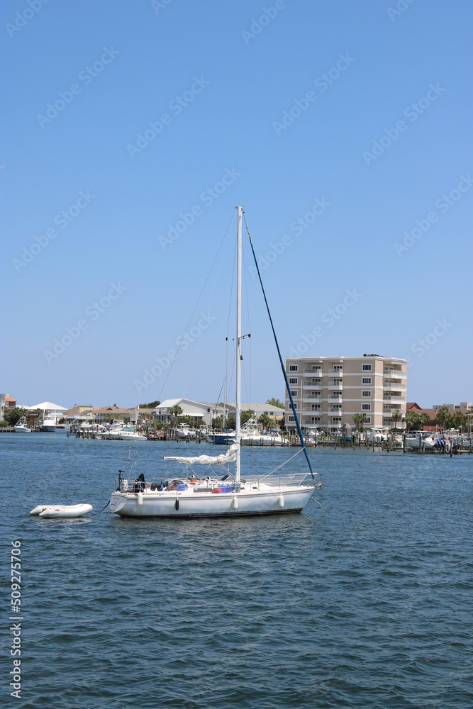 sailboat sailing in harbor near the coastline of destin, florida