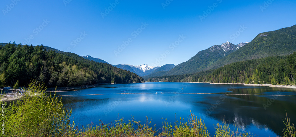 Capilano Lake Cleveland Park in springtime sunny day. Panoramic view. North Vancouver, BC, Canada.