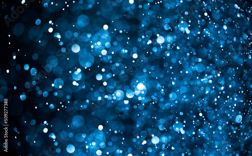 Bokeh glitter on blue light effects background. photo