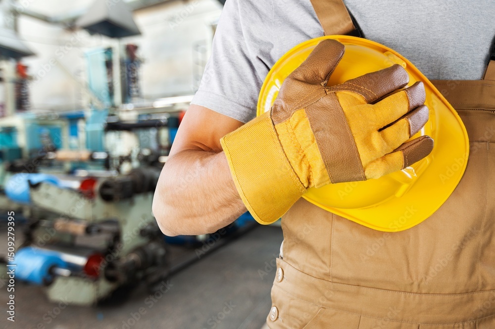 A man workers engineering standing with safety helmet in front of indoor factory. Concept of smart industry worker operating. A man workers engineering standing with safety helmet in front of indoor factory. Concept of smart industry worker operating.