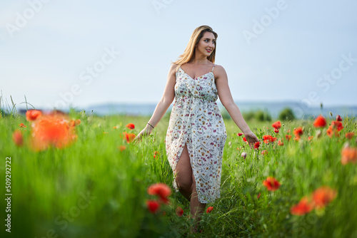 Fotografie Beautiful plus size woman in a poppy field