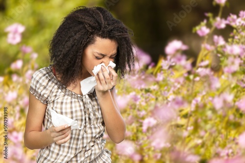 Woman allergic suffering from seasonal allergy at spring garden. Spring allergy concept