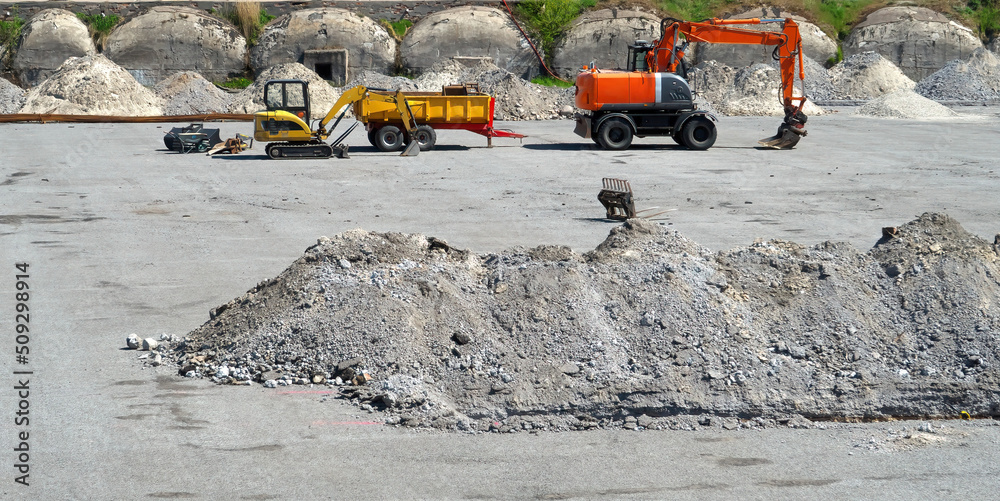 Construction site. Small and large excavators, cargo trailer.