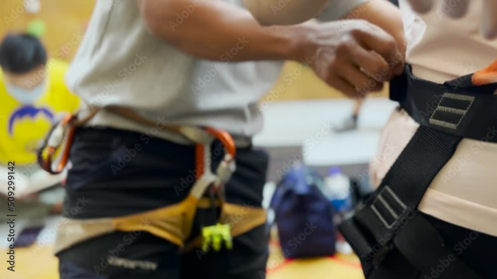 Putting on Safety Harness at Wall Climbing Gym Putting on Safety Harness at Wall Climbing Gym