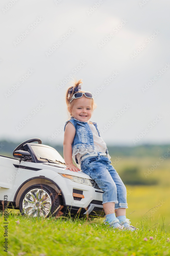 little girl standing near her baby car little girl standing near her baby car