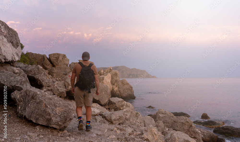 hiker walking on the shore of sea hiker walking on the shore of sea