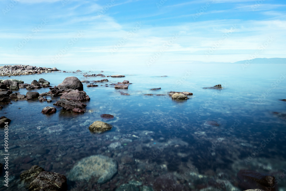 Long exposure photo of sea, rocks and sunset. Concept of relax, calm, tranquil and inner peace. Long exposure photo of sea, rocks and sunset. Concept of relax, calm, tranquil and inner peace.