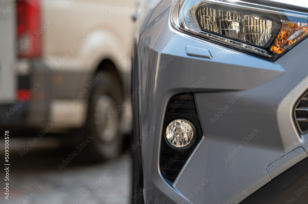 close-up detail on headlight of modern  car,  part of the front bumper