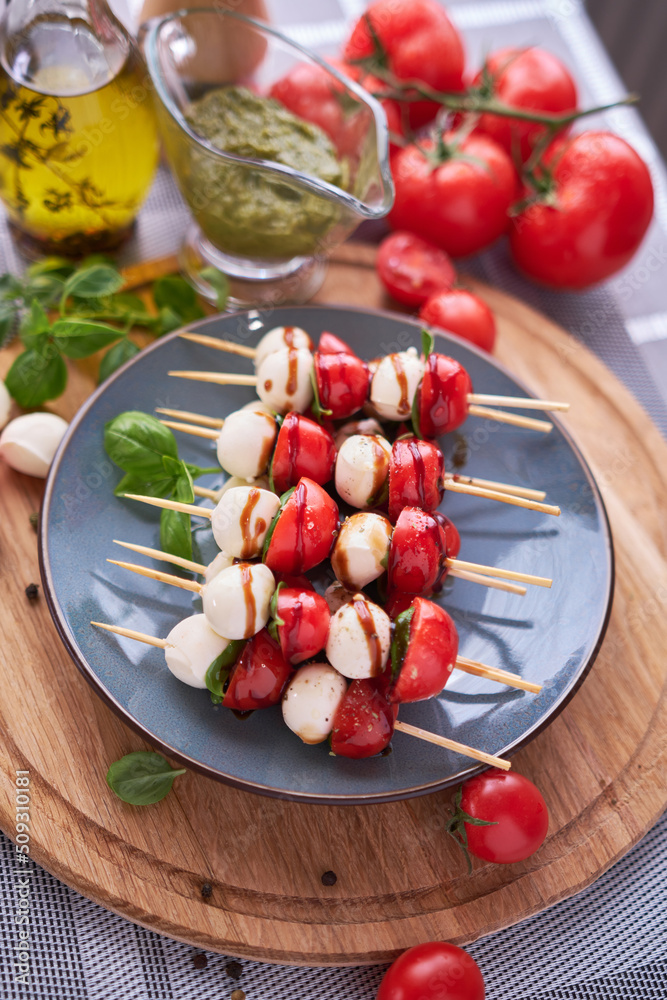 Caprese salad - Mini mozzarella cheese in glass bowl, tomato and basil Caprese salad - Mini mozzarella cheese in glass bowl, tomato and basil