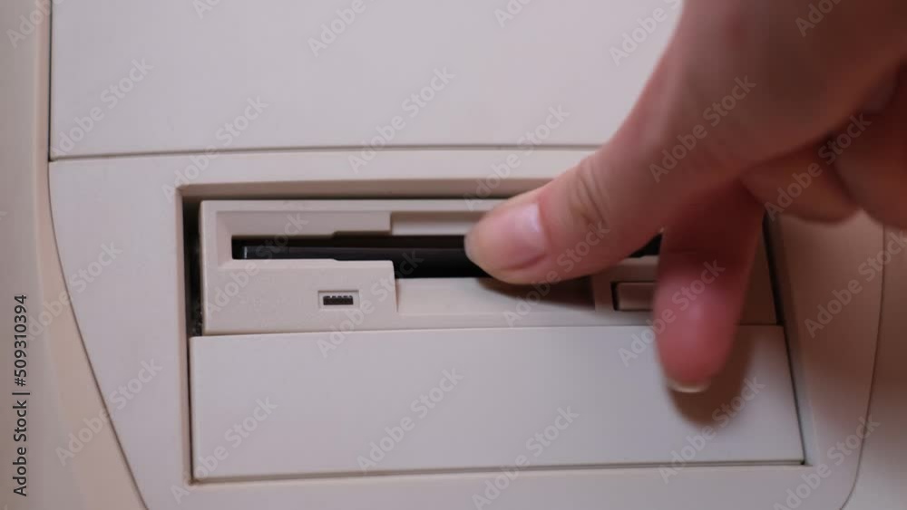 Close-up of installing floppy disk in retro computer. Diskette scan. Retro computer