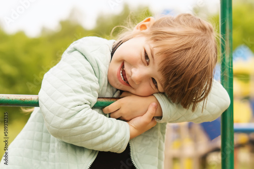 Billede på lærred A happy 4-year-old little girl is having fun on the playground and smiling