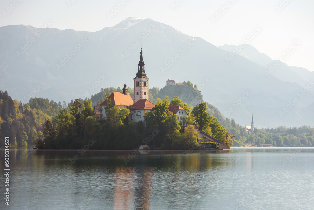 Alpine Bled lake in Slovenia, amazing nature and scenic landscape with church on island and castle on a cliff.