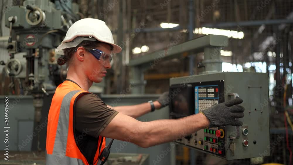 Industrial worker operating cnc turning machine in metal machining industry